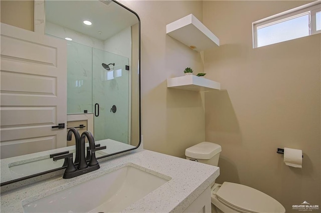 bathroom featuring an enclosed shower, vanity, and toilet