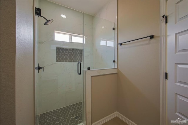 bathroom with a shower with door