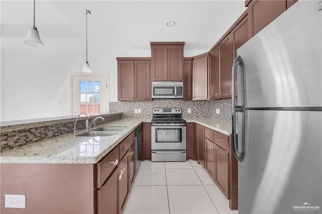 kitchen featuring sink, tasteful backsplash, decorative light fixtures, light tile patterned floors, and appliances with stainless steel finishes