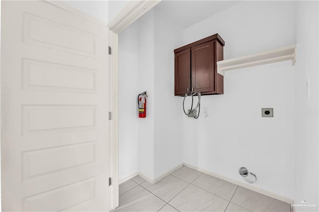 washroom with hookup for an electric dryer and light tile patterned floors