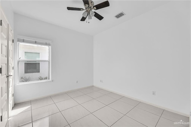 spare room with ceiling fan and light tile patterned flooring