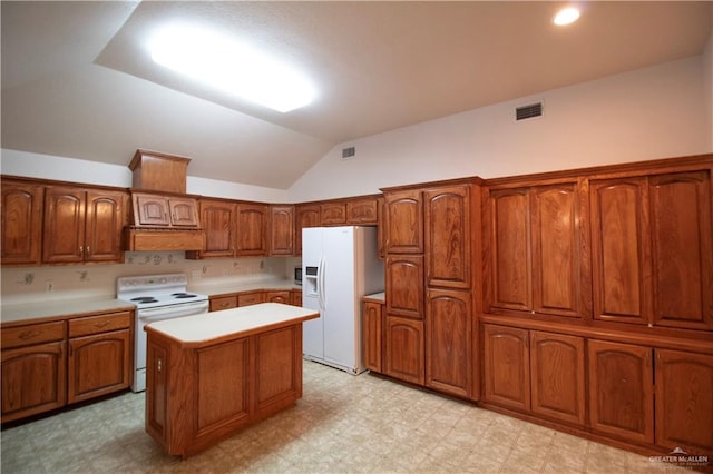 1717 Edward Dr, Edinburg, TX 78539 - kitchen with white appliances, light floors, vaulted ceiling, light countertops, and brown cabinetry