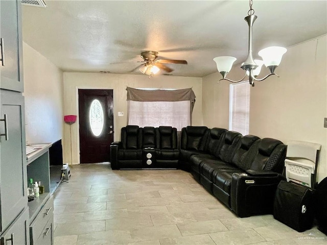 living room with ceiling fan with notable chandelier