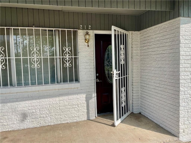 view of exterior entry with brick siding