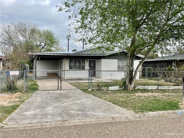 view of front facade featuring a gate, brick siding, fence, and driveway