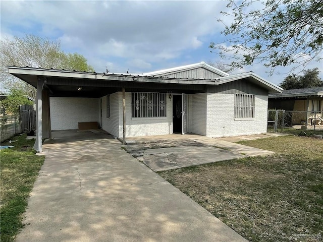 view of front of property with driveway, fence, a carport, and brick siding