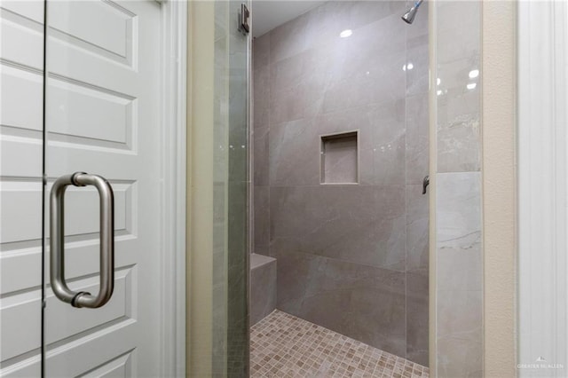 bathroom with a shower with door