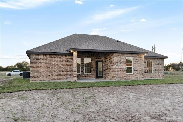 rear view of property with central air condition unit, a patio, and a yard