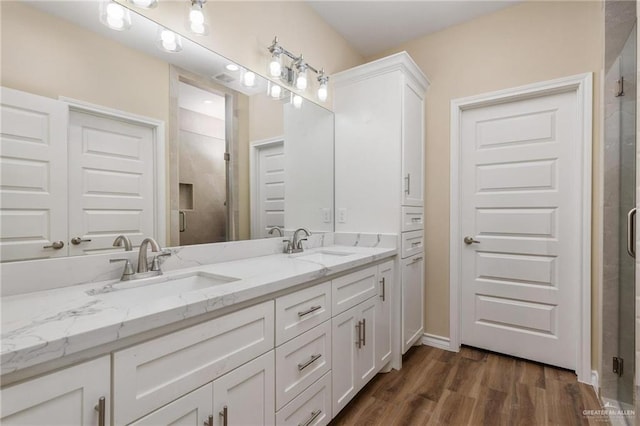 bathroom featuring vanity, an enclosed shower, and wood-type flooring