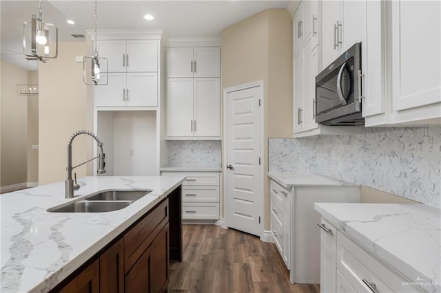 kitchen featuring sink, hanging light fixtures, dark hardwood / wood-style floors, decorative backsplash, and white cabinetry