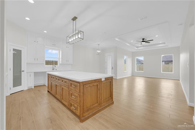 2205 Cardinal Dr, Weslaco, TX 78596 - kitchen with white cabinetry, light wood finished floors, light countertops, hanging light fixtures, and recessed lighting