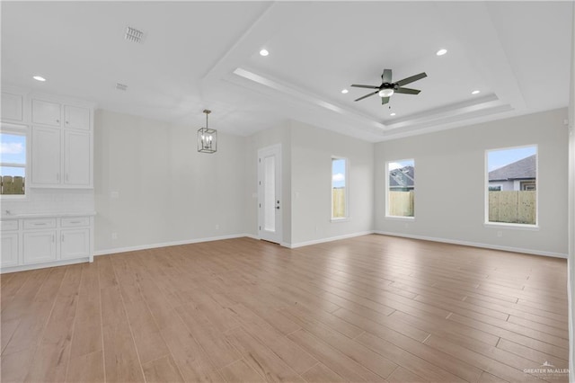 2205 Cardinal Dr, Weslaco, TX 78596 - unfurnished living room with a tray ceiling, healthy amount of natural light, ceiling fan, light wood-type flooring, and recessed lighting