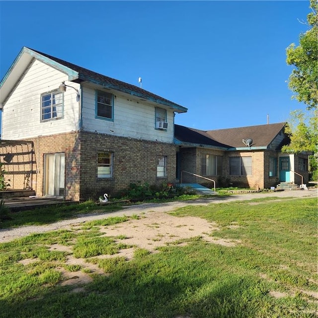 rear view of property with cooling unit and a lawn