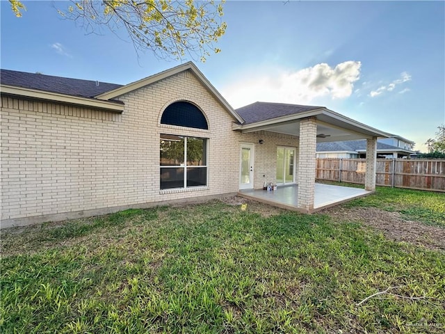 rear view of house with a yard and a patio