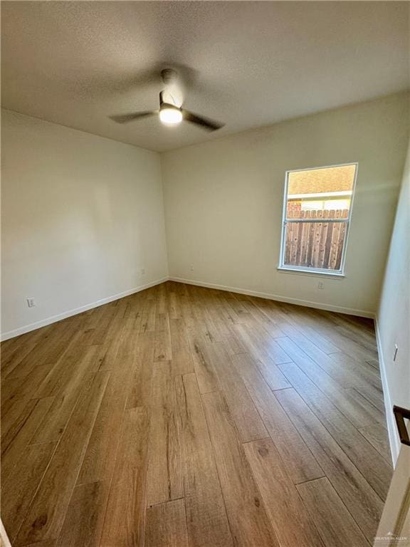 spare room with ceiling fan, a textured ceiling, and light hardwood / wood-style floors