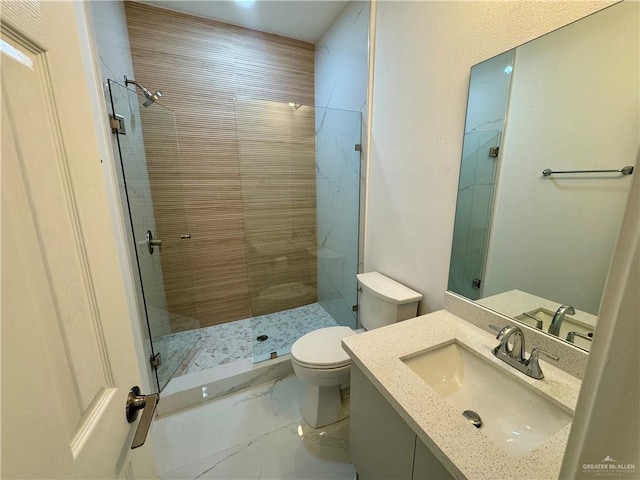 bathroom with vanity, toilet, and tiled shower