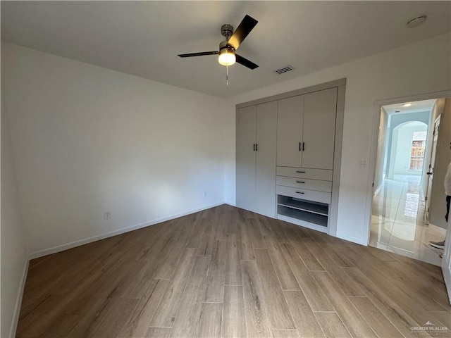 unfurnished bedroom with light hardwood / wood-style floors, a closet, and ceiling fan