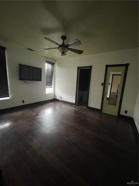 unfurnished room featuring ceiling fan and dark wood-type flooring