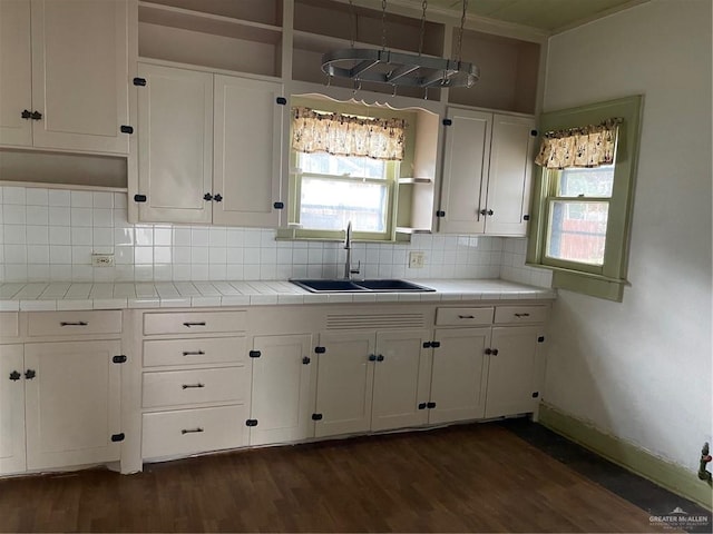 kitchen with white cabinets, tasteful backsplash, tile counters, and sink