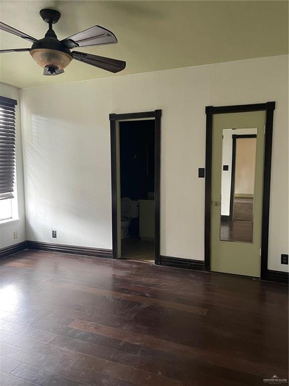 empty room with ceiling fan and dark wood-type flooring