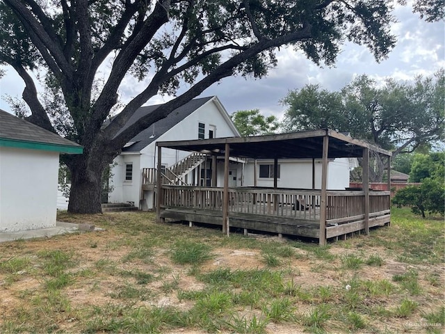 rear view of property with a lawn and a deck