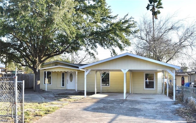 view of front of home featuring an attached carport, driveway, and fence