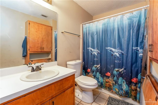 bathroom featuring tile patterned flooring, vanity, toilet, and a textured ceiling