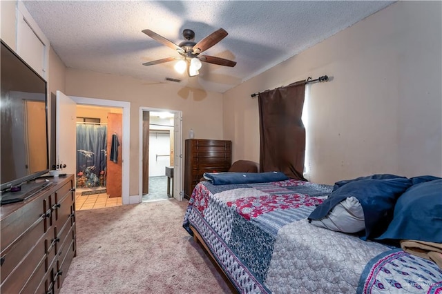 bedroom with ensuite bath, ceiling fan, a textured ceiling, light colored carpet, and a closet