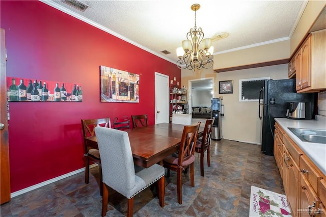 dining room featuring a textured ceiling, ornamental molding, sink, and an inviting chandelier