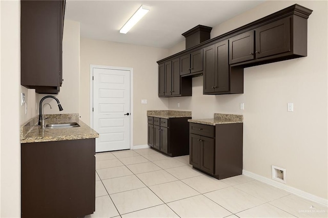 109 Aaron St, Mercedes, TX 78570 - kitchen featuring a sink, baseboards, and dark brown cabinets