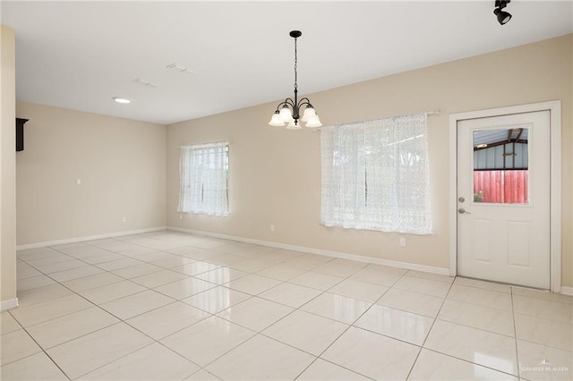 109 Aaron St, Mercedes, TX 78570 - empty room featuring a chandelier, light tile patterned flooring, and baseboards