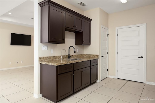 109 Aaron St, Mercedes, TX 78570 - kitchen featuring a sink, dark brown cabinetry, light tile patterned floors, baseboards, and recessed lighting