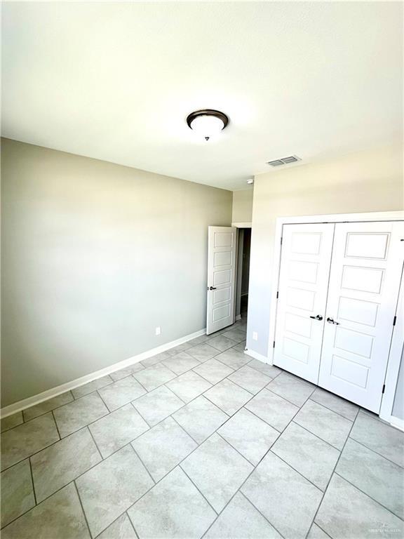 unfurnished bedroom with a closet and light tile patterned floors