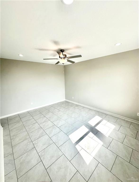 tiled empty room with ceiling fan