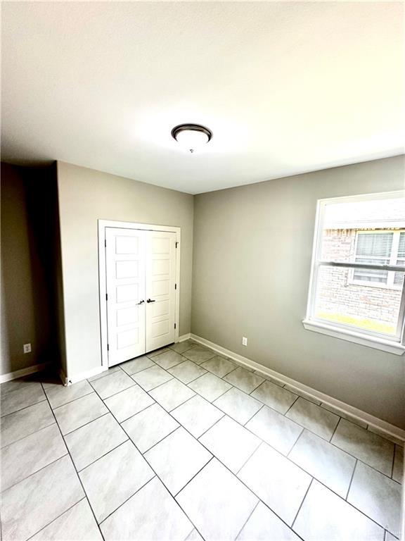 unfurnished bedroom featuring a closet and light tile patterned floors