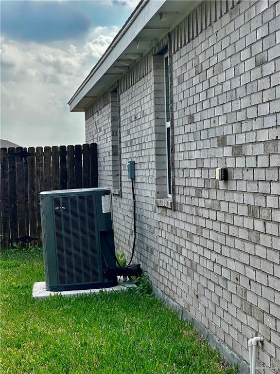 view of side of home featuring a yard and central AC unit