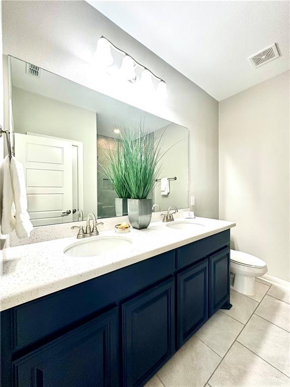 bathroom with vanity, tile patterned floors, and toilet