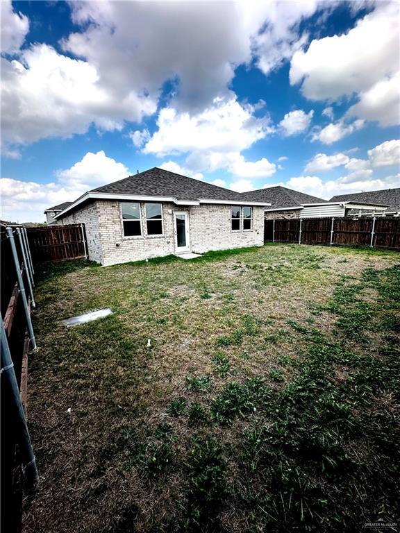 rear view of house featuring a lawn