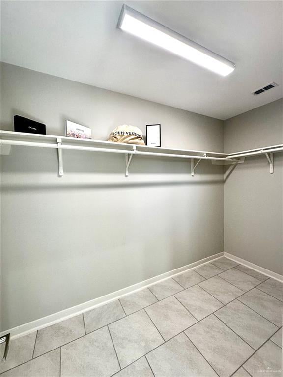 spacious closet featuring light tile patterned floors