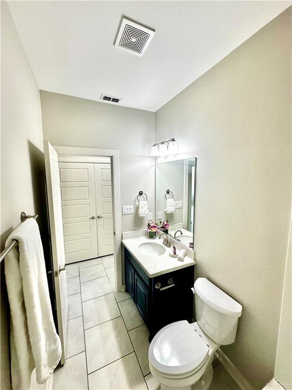 bathroom featuring tile patterned floors, vanity, and toilet