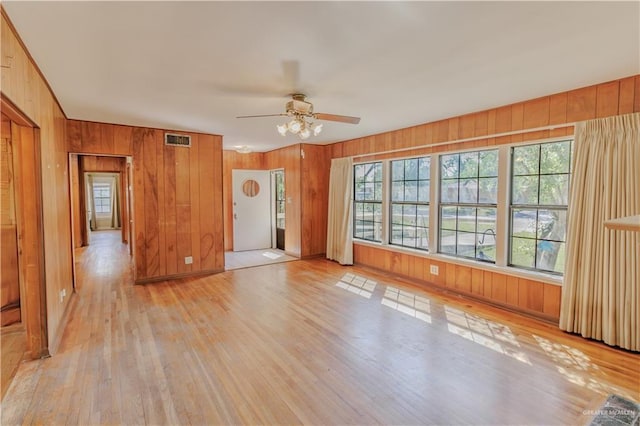 1150 N Bowie St, San Benito, TX 78586 - spare room with wood walls, light wood-style flooring, and ceiling fan