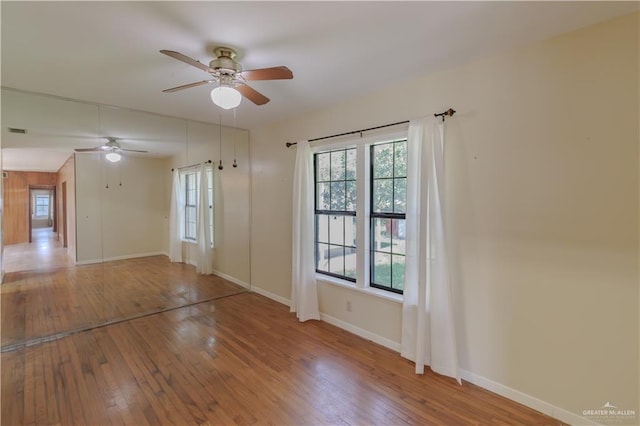 1150 N Bowie St, San Benito, TX 78586 - unfurnished room with a ceiling fan, hardwood / wood-style floors, and baseboards
