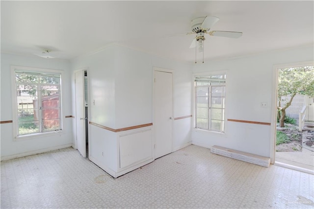 1150 N Bowie St, San Benito, TX 78586 - spare room featuring ceiling fan, tile patterned floors, healthy amount of natural light, and baseboards
