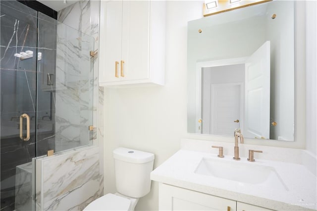 bathroom with a shower with door, vanity, and toilet