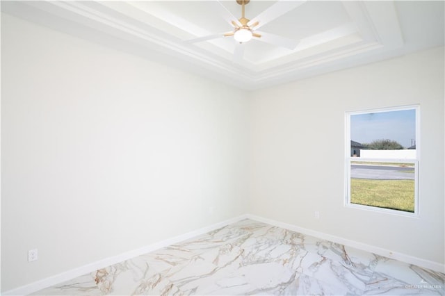 empty room with a raised ceiling and ceiling fan