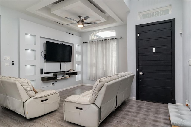 living room featuring a tray ceiling and ceiling fan