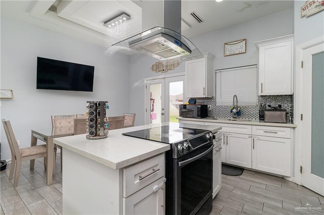 kitchen featuring white cabinetry, sink, black appliances, and island range hood