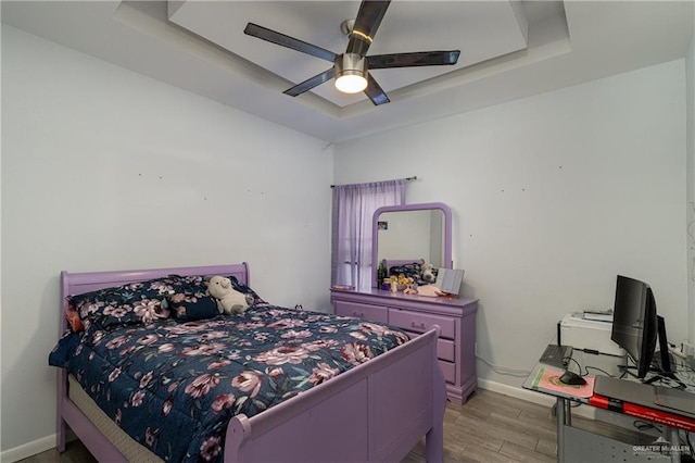 bedroom with ceiling fan and a raised ceiling