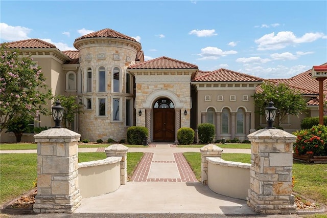 mediterranean / spanish home with a front lawn