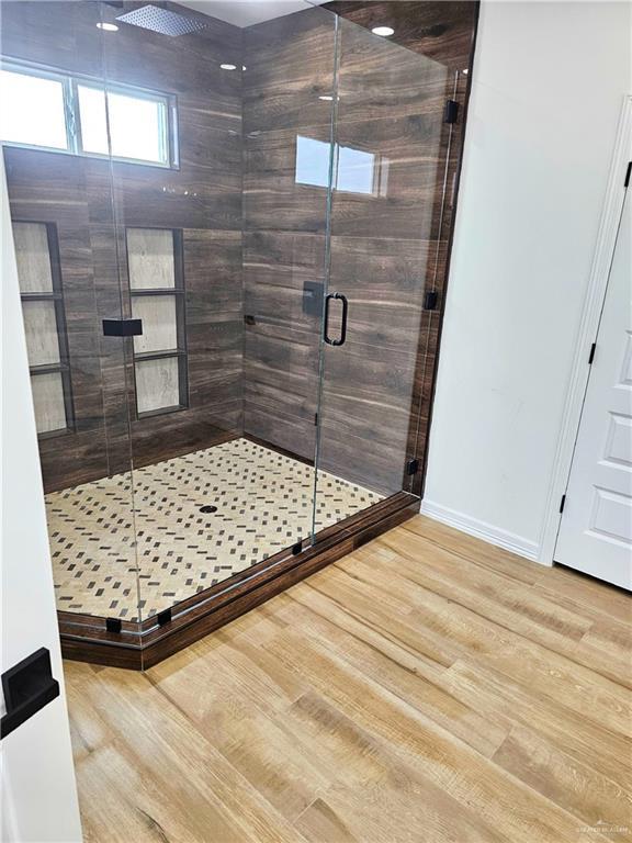 bathroom with walk in shower and wood-type flooring